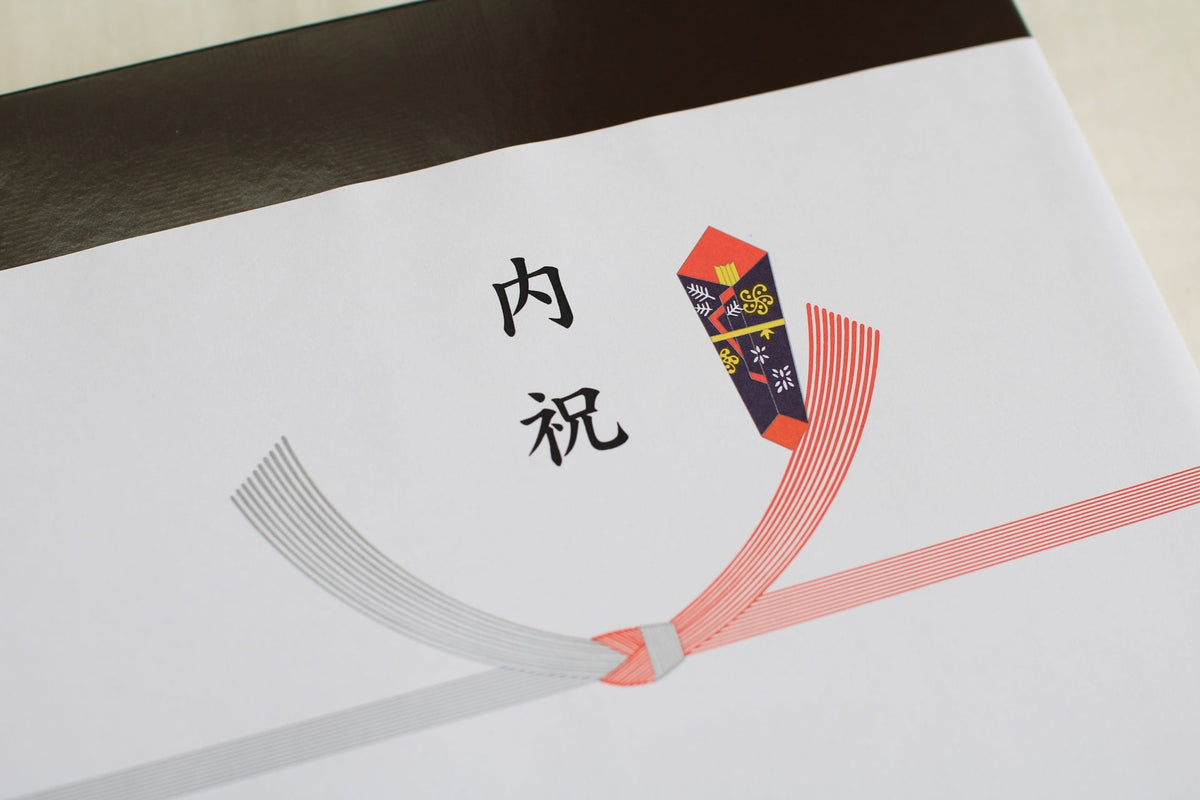 「内祝」と書かれたのし紙を掛けた箱。紅白の水引を結び切りにして、右上にのしが付いている
