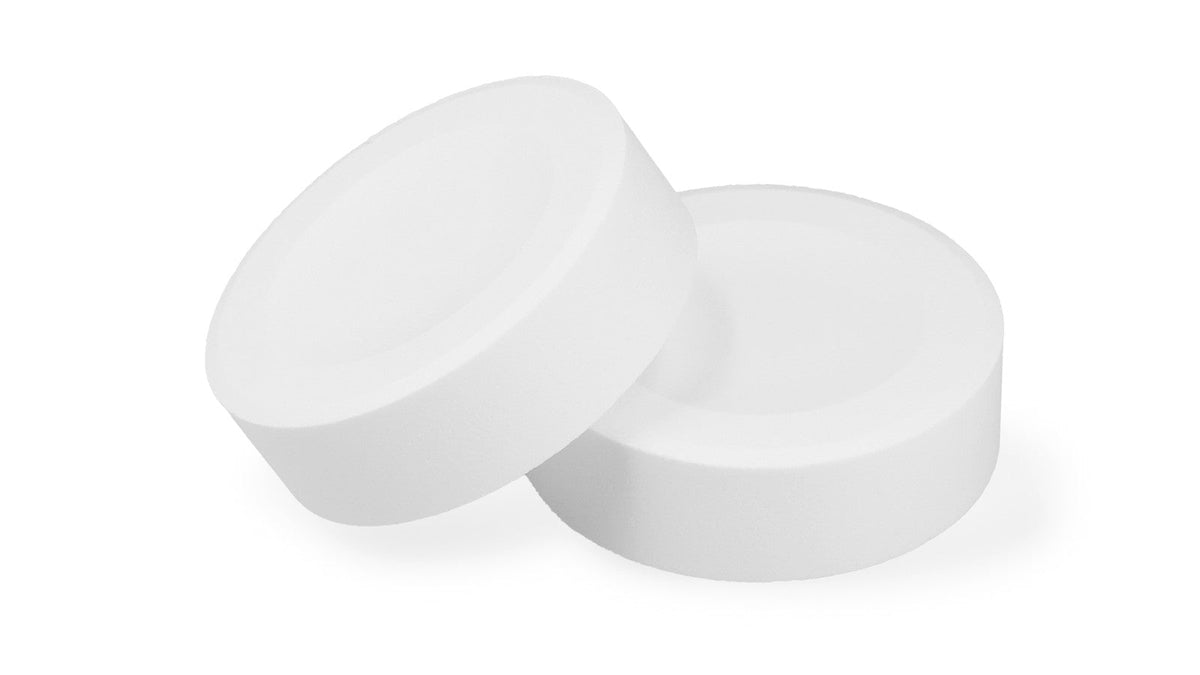 白い背景に、1つをもう1つに立てかけて置いた ReNELU SPARKLING SPA TABLET の錠剤2つ