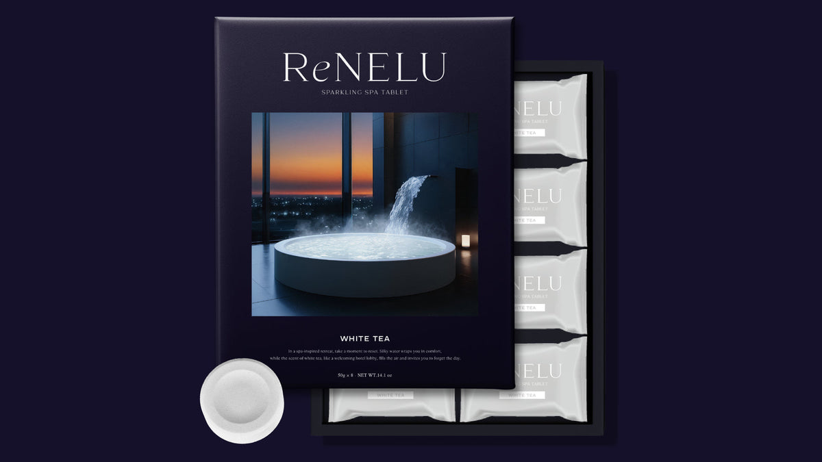 紺色の背景に置いた ReNELU SPARKLING SPA TABLET の紺の化粧箱と、白い個包装・錠剤