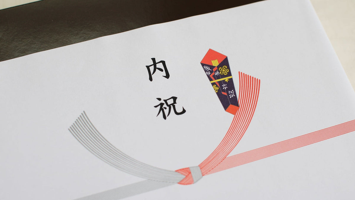 「内祝」と書かれたのし紙を掛けた箱。紅白の水引を結び切りにして、右上にのしが付いている